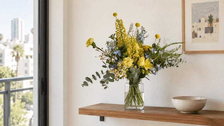 זר Wildflower צהוב וכחול על מדף עץ צר בדירה תל אביבית קטנה